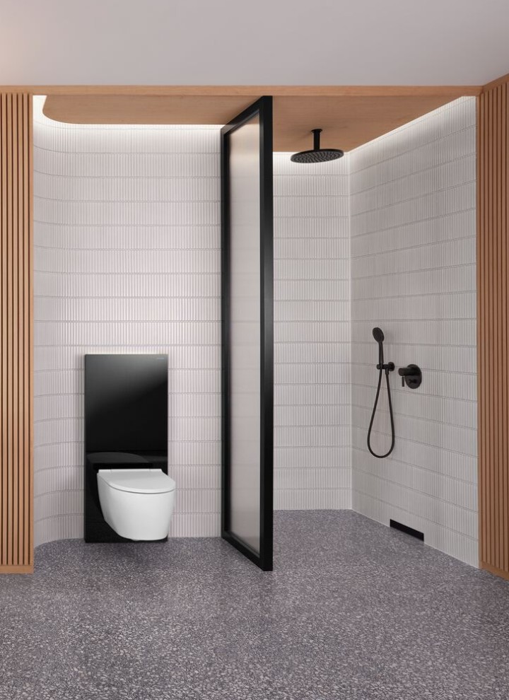 Ett badrum med en trävägg, dusch och toalett i svart och vitt