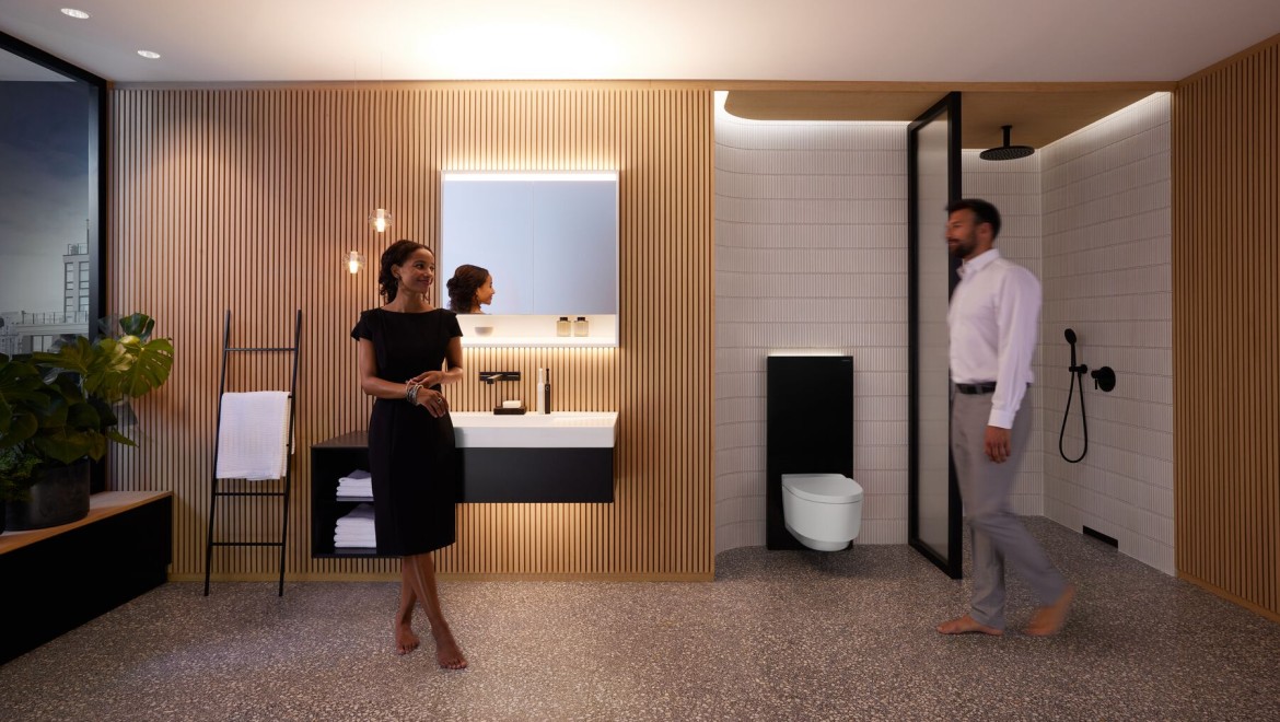 Man och kvinna i perfekt upplyst badrum med produkter från Geberit ONE