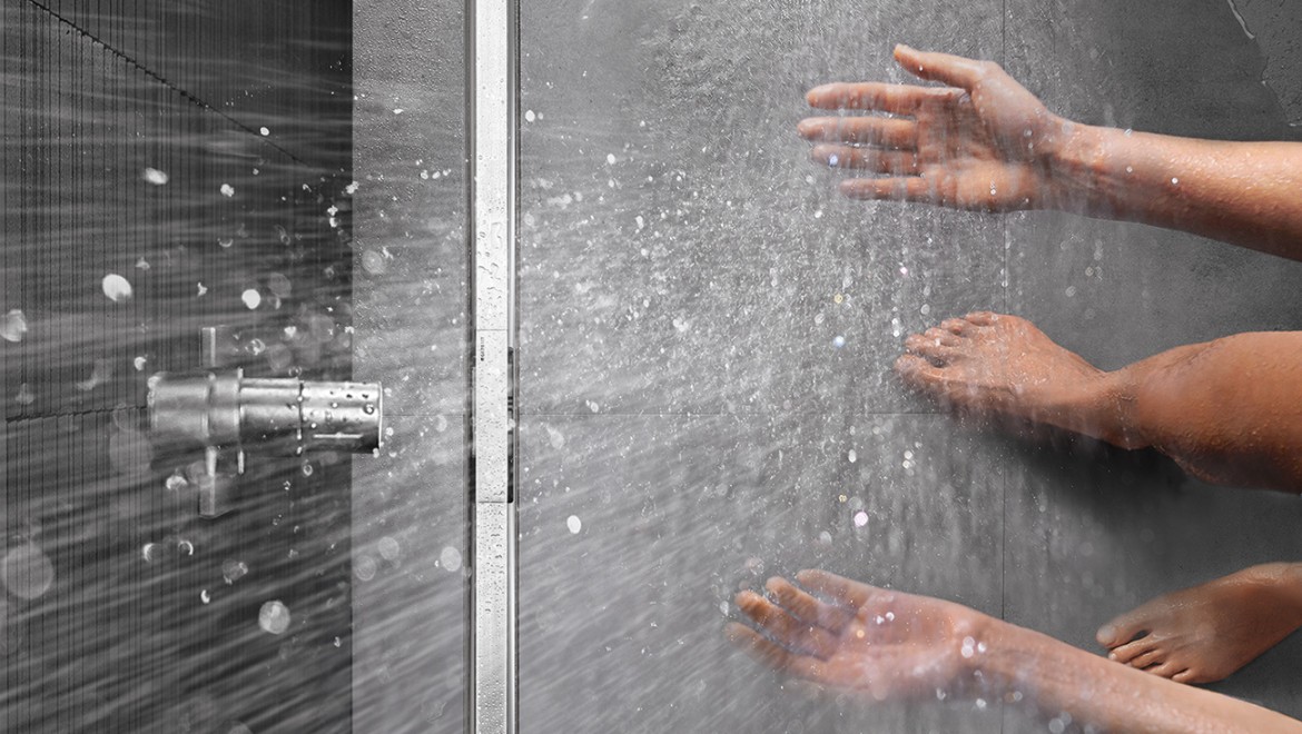 Person som duschar i en dusch med Geberit CleanLine golvränna