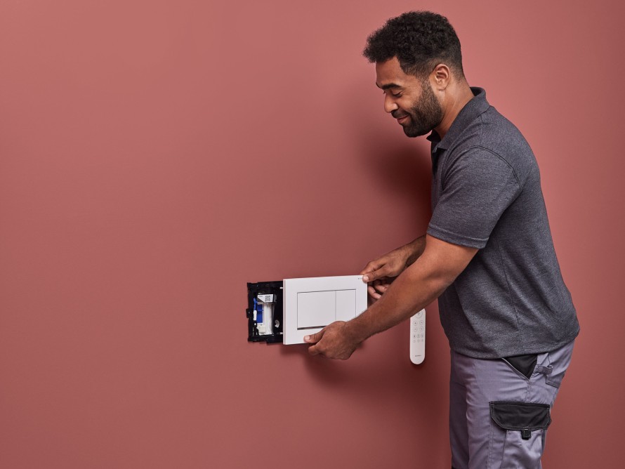 En man monterar Geberit DuoFresh luktutsugningsenhet En man monterar Geberit DuoFresh luktutsugningsenhet