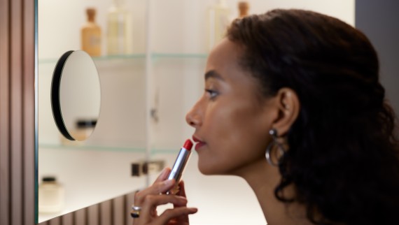 Kvinna som lägger sin makeup framför en spegel från Geberit (© Geberit)