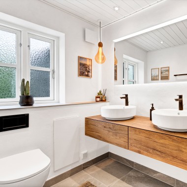 Ljust, renoverat badrum med två runda tvättställ, en stor spegel och badrumsmöbler i trä (© @triner2 and @strandparken3)