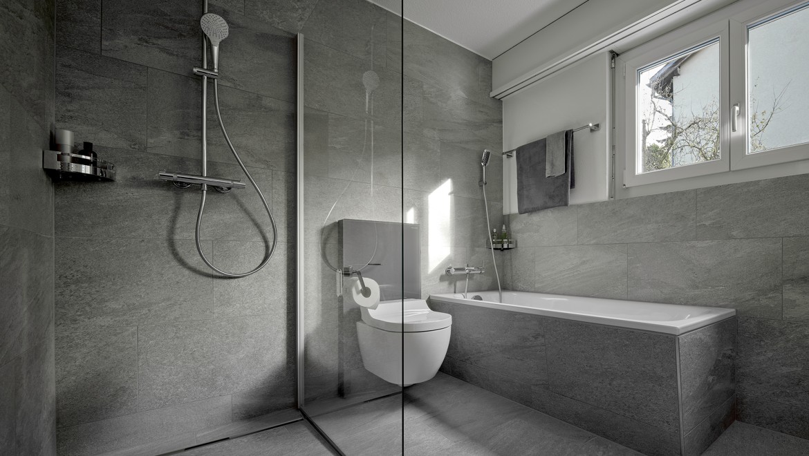 En duschtoalett mellan en modern duschlösning och ett badkar