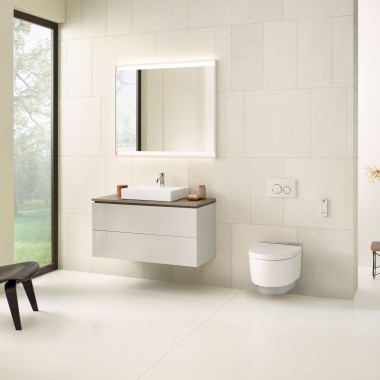 Beige badrum med spegelskåp underskåp, spolplatta och porslinsprodukter från Geberit