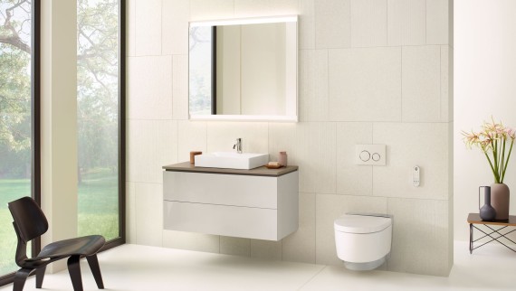 Vitt badrum med spegelskåp, underskåp, spolplatta och keramik från Geberit