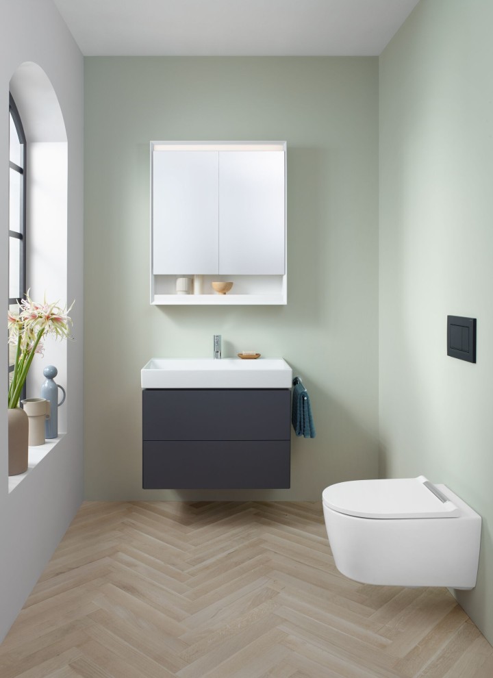 Vy över en gästtoalett med en vägghängd WC, spegelskåp och tvättställ med underskåp från Geberit ONE badrumsserie