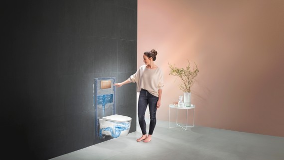 Kvinna som aktiverar spolningen av Geberit WC-system (© Geberit)
