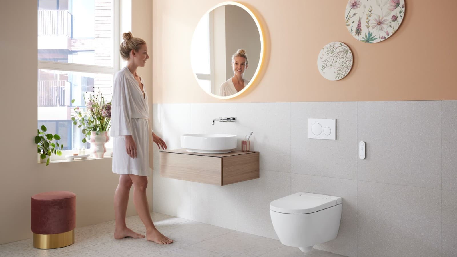 Kvinna i badrum med duschtoaletten Geberit AquaClean Alba Kvinna i badrum med duschtoaletten Geberit AquaClean Alba