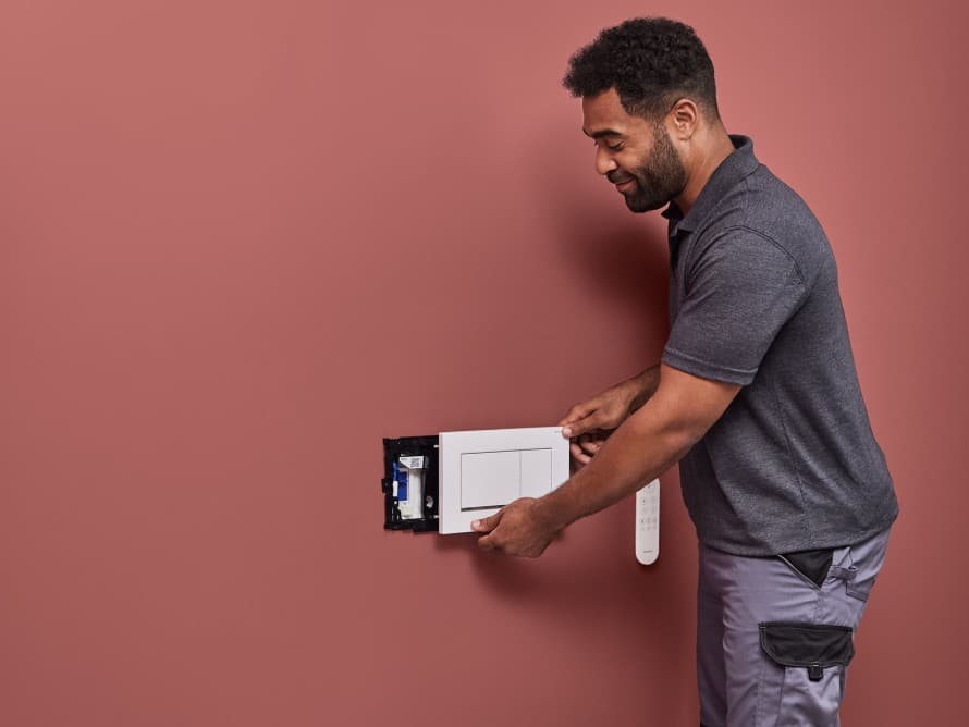 En man monterar Geberit DuoFresh luktutsugningsenhet En man monterar Geberit DuoFresh luktutsugningsenhet